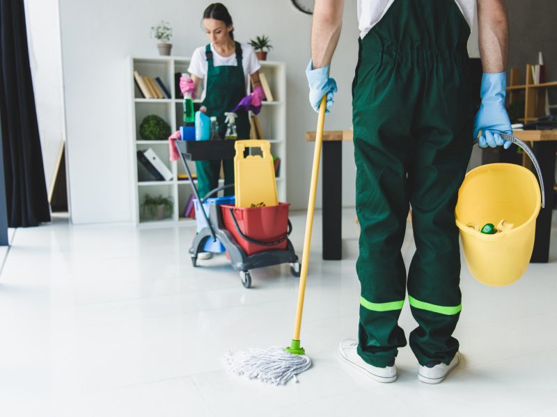 cropped-shot-of-young-cleaning-company-workers-holding-various-cleaning-equipment-in-office
